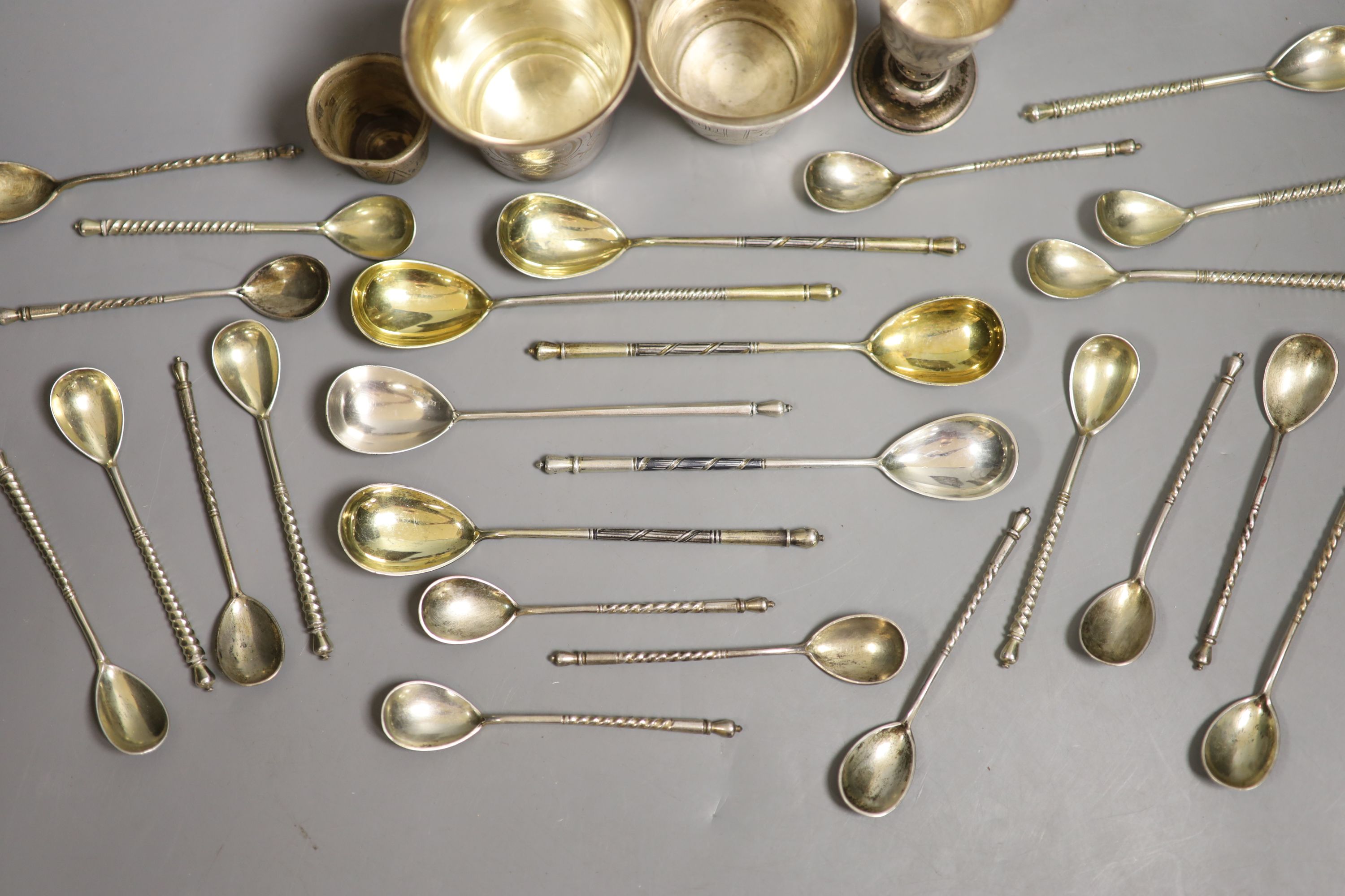 Four assorted 19th century Russian 84 zolotnik small beakers, largest 93mm and twenty five similar tea or coffee spoons including a set of eight with niello decoration